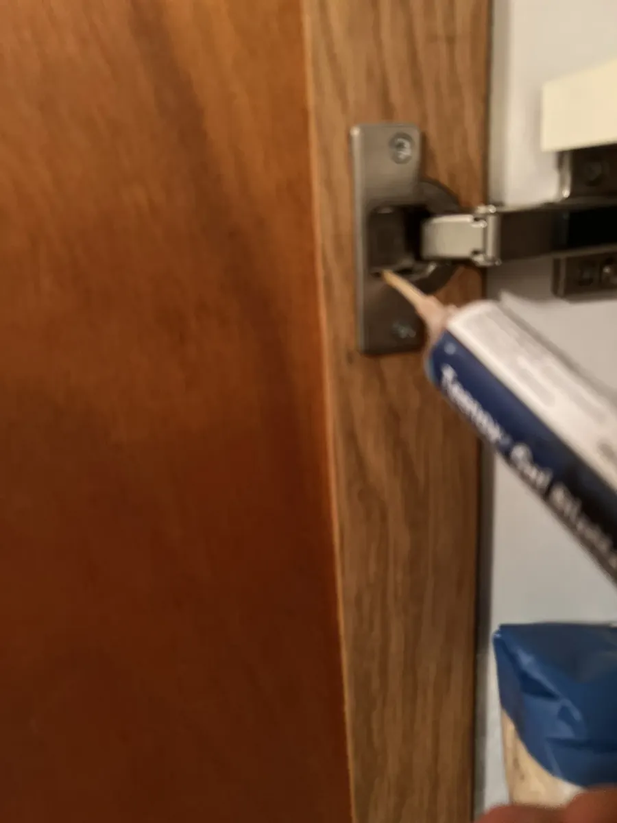 Application préventive de gel anti-cafards sur un montant de porte d'appartement