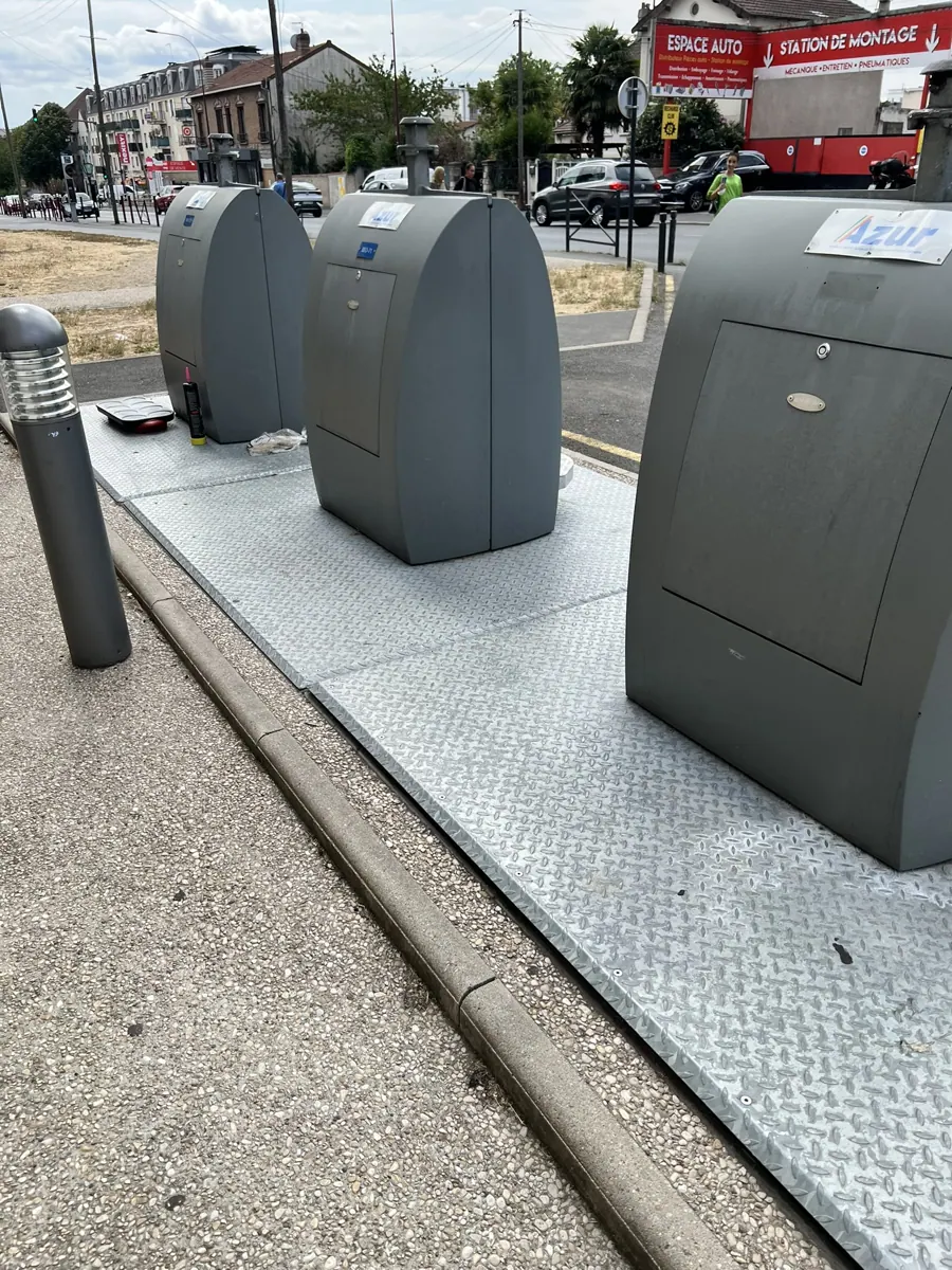 Conteneurs à déchets enterrés aux abords d'un magasin proche d'une résidence
