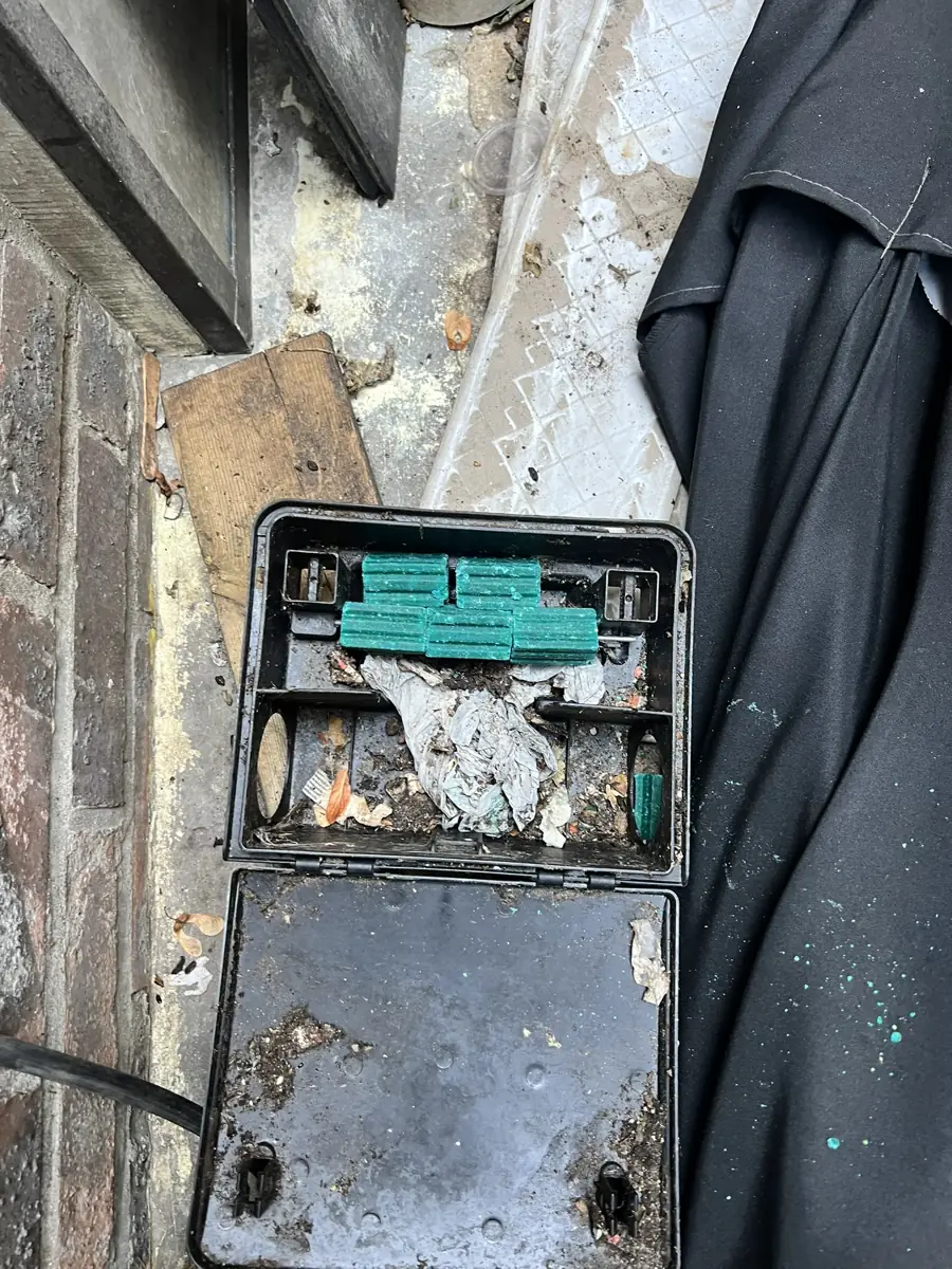 Poste d'appâtage rechargé avec bloc rodenticide neuf contre le mur extérieur d'un restaurant